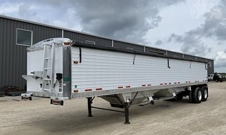 Side view of a bulk trailer with aluminum wall panels and tarp